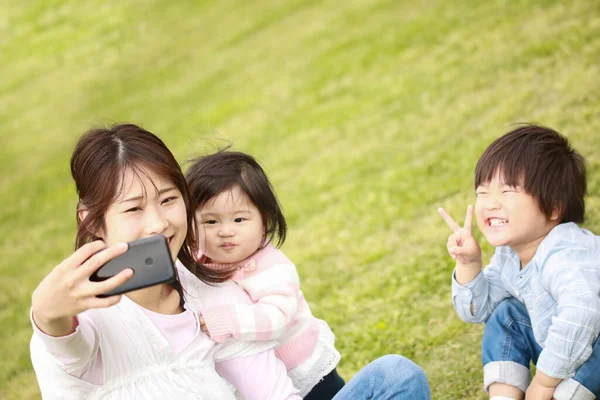 asian family taking selfie with mobile phone