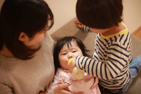 Little Japanese Boy Helping His Mother Feed His Little Sister — Stock Photo, Image