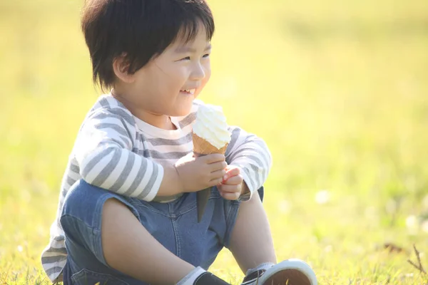 公園でアイスクリームを食べる少年 — ストック写真