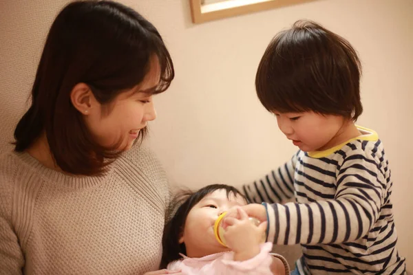 Piccolo Ragazzo Giapponese Aiutando Sua Madre Nutrire Sua Sorellina Con — Foto Stock