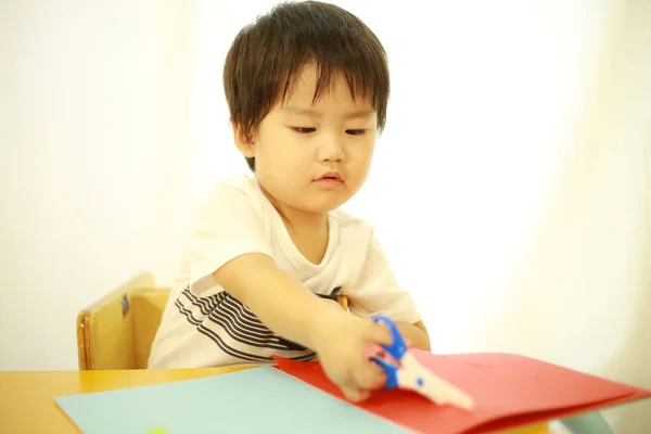 アジア系の少年がハサミで遊ぶ — ストック写真