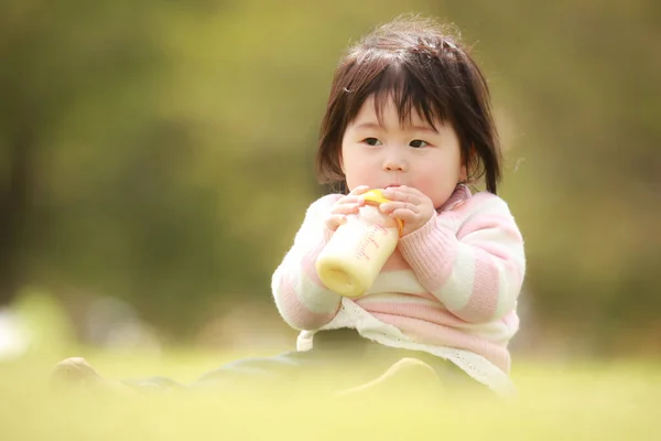 Portrait Jeune Asiatique Bébé Avec Bouteille Sur Pelouse — Photo