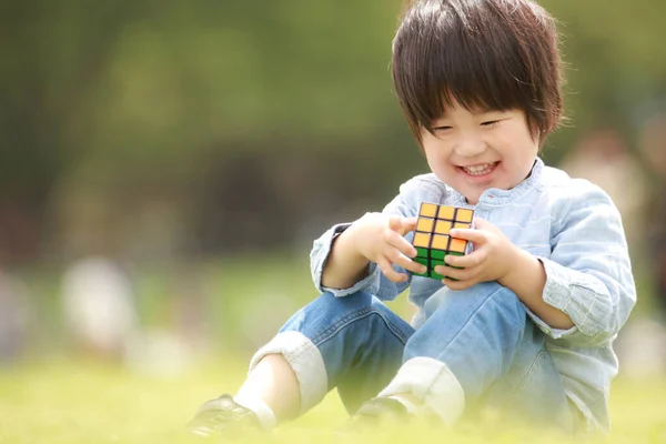 Мальчик Играет Игрушечным Кубиком Лавке — стоковое фото