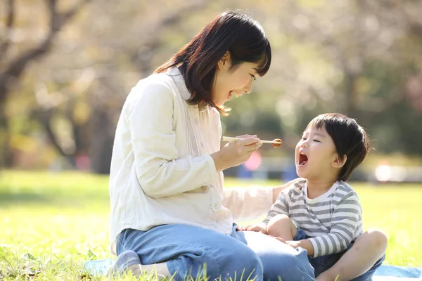 公園で息子と昼食を共にしたアジア系の母親は — ストック写真