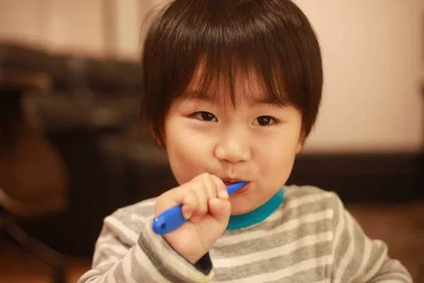 Küçük Japon Çocuk Dişlerini Mavi Diş Fırçasıyla Fırçalıyor — Stok fotoğraf