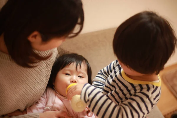 Pequeño Chico Japonés Ayudando Madre Alimentar Hermana Pequeña Con Leche —  Fotos de Stock