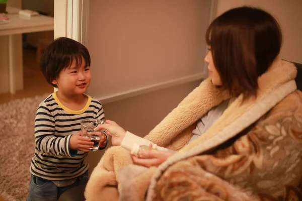 Küçük çocuk hasta annesine yardım ediyor.