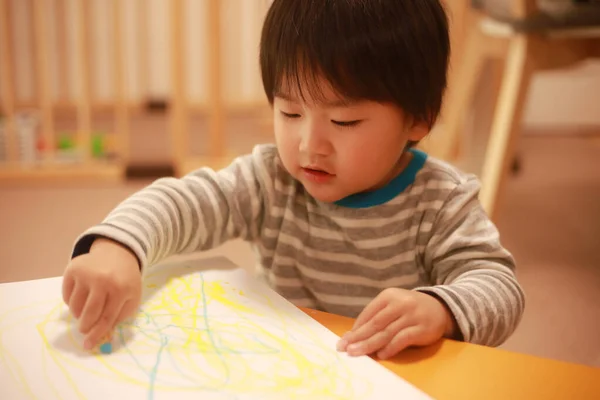 可爱的小男孩在家里画一本书 — 图库照片