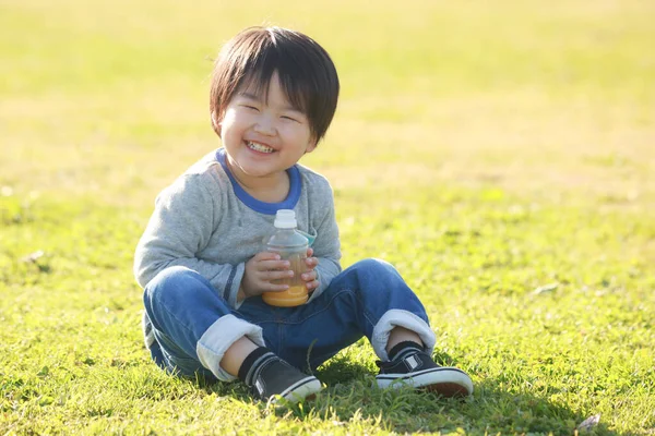 公園での幸せな少年ジュースの肖像画 — ストック写真