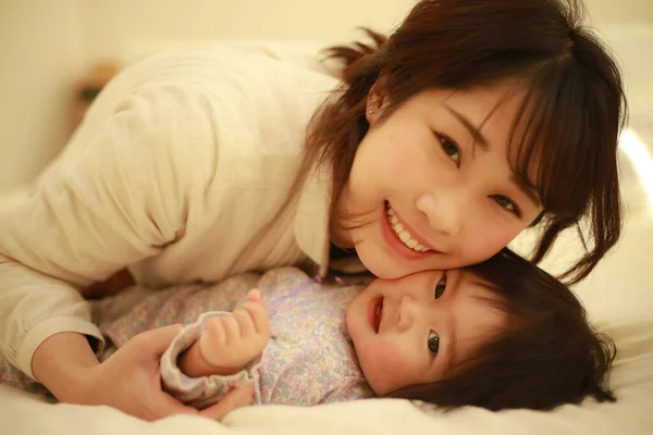Young Asian Mother Cuddling Adorable Baby Home — Stock Photo, Image