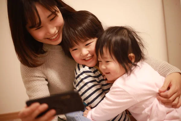 Happy Asian Family Using Mobile Phone Watch Shows — Stock Photo, Image