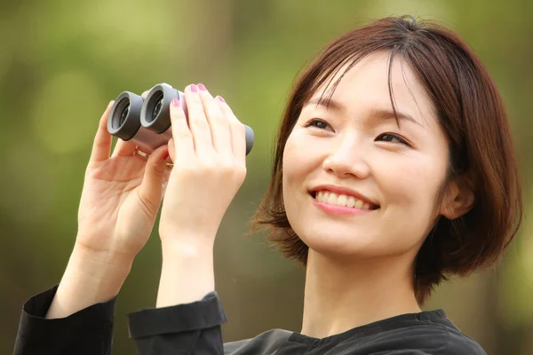 公园里拿着双筒望远镜的年轻亚洲女人的肖像 — 图库照片