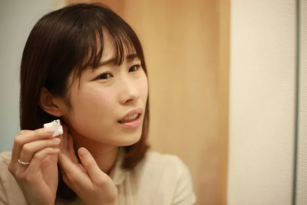 アジア系の若い女性が耳を貫通し — ストック写真