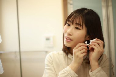 Asyalı genç bir kadının portresi. Kulak delici.