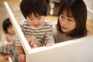 Küçük oğlu olan Asyalı kadın yeni evinde toplanıyor.