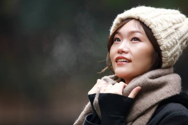 Sonbahar parkında poz veren Asyalı genç kadının portresi. 