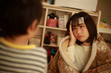 Küçük çocuk hasta annesine yardım ediyor.