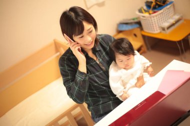 Kadın çocuğuyla birlikte evden çalışıyor.