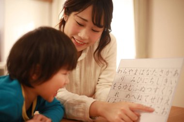 Küçük Asyalı çocuk annesiyle hiyeroglifleri öğreniyor.
