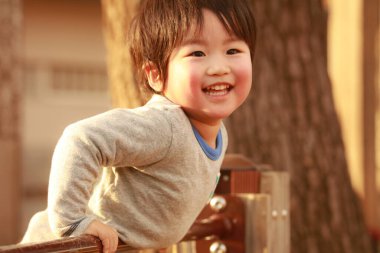 Platformda oynayan mutlu küçük çocuğun portresi