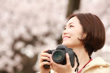 Parkta kamerası olan genç bir kadın.