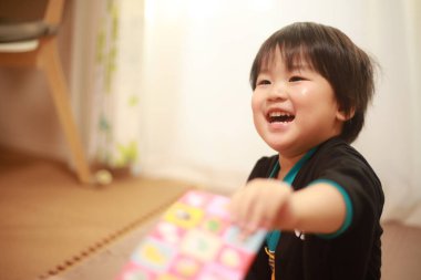 Sevimli, mutlu, küçük çocuk evde hediye tutuyor. 