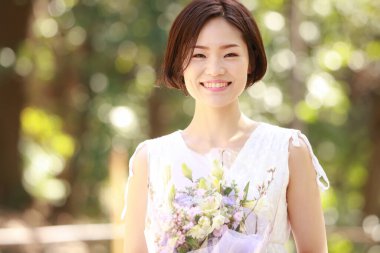 Açık havada gülümseyen güzel bir Asyalı kadının portresi.