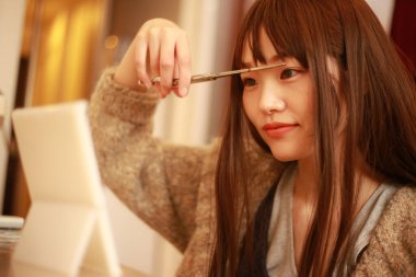 Güzel Asyalı kadın saçını kesiyor. 