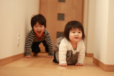 Evde oynayan Asyalı küçük çocuklar.