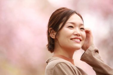 Pembe saçlı ve gülümseyen Asyalı güzel bir kadının portresi.