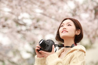 Parkta kamerası olan genç bir kadın.