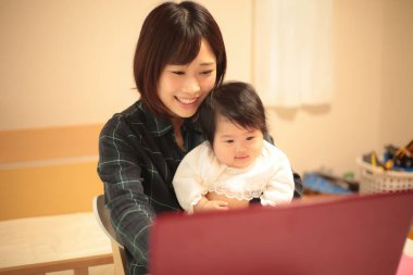 Kadın çocuğuyla birlikte evden çalışıyor.