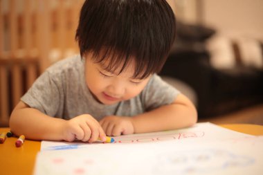 Yakışıklı Asyalı bebek oyuncakla oynuyor.