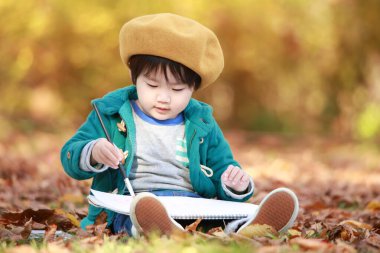 Parkta çizim yapan sevimli küçük çocuk.