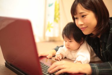 Kadın çocuğuyla birlikte evden çalışıyor.