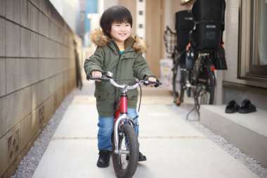 Şehirde bisikleti olan küçük bir çocuk