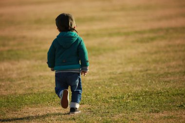 Parkta koşan yakışıklı Asyalı çocuk.