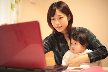 Kadın çocuğuyla birlikte evden çalışıyor.