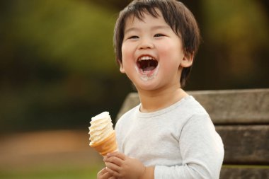 Dışarıda dondurması olan sevimli çocuk.