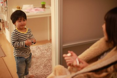 Küçük çocuk hasta annesine yardım ediyor.