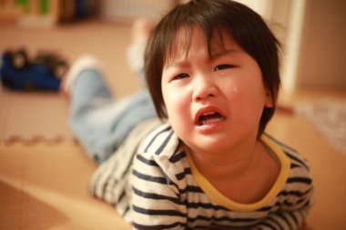 Evde ağlayan küçük şirin bir çocuğun portresi.