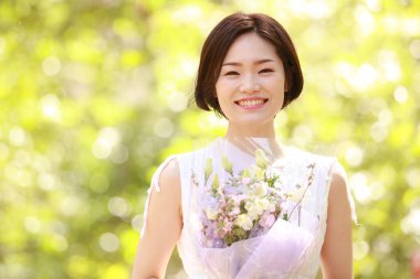 Açık havada gülümseyen güzel bir Asyalı kadının portresi.