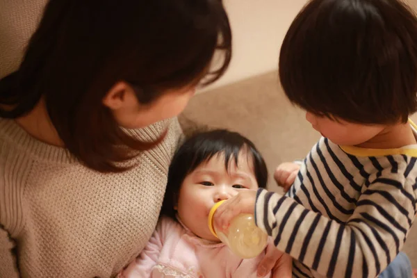 Pequeño Chico Japonés Ayudando Madre Alimentar Hermana Pequeña Con Leche —  Fotos de Stock