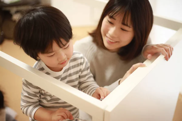 Asiatin Mit Kleinem Sohn Baut Tisch Neuen Zuhause Zusammen — Stockfoto