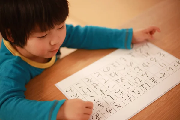 Küçük Çocuk Rakamlarla Kağıda Yazıyor — Stok fotoğraf