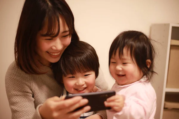 Happy Asian Family Using Mobile Phone Watch Shows — Stock Photo, Image