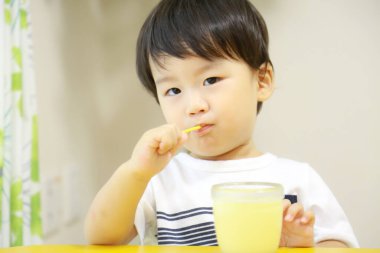 Asyalı bir çocuğun yemek yeme görüntüsü. 