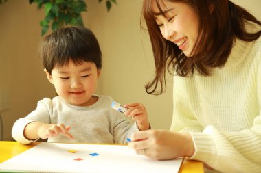 Genç anne ve tatlı küçük oğlu evde birlikte zaman geçirip, eğitim oyunları oynuyorlar.