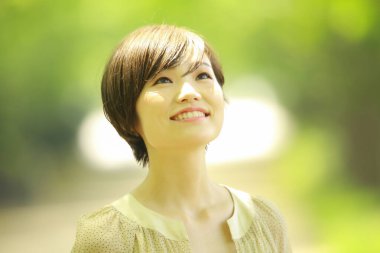 Parkta poz veren Asyalı genç kadının portresi. 