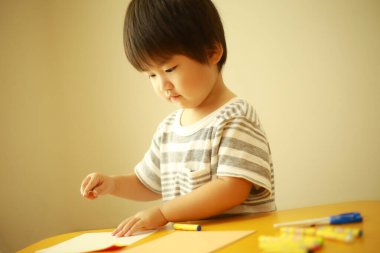 Evde çizim yapan şirin bir çocuk.